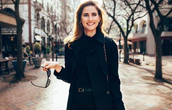 Beautiful caucasian woman walking along the road in the city.