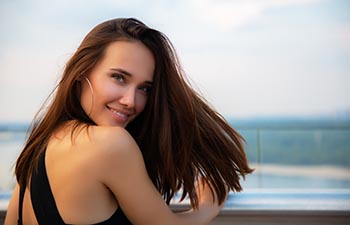 Fashion model wearing black elegant dress posing outdoor.