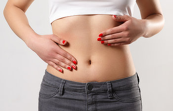 woman is touching her slim stomach with two hands